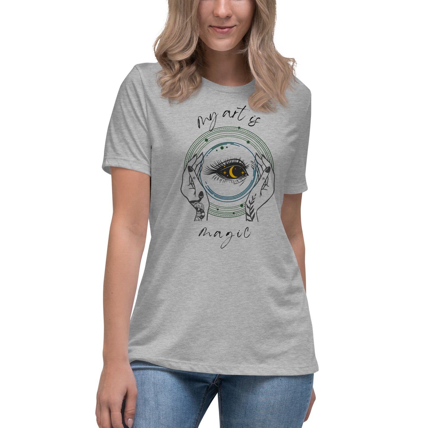 Close up of My Art is Magic T-shirt with athletic heather grey background and witchy hands with a long lashed eye with a crescent moon as pupil. 